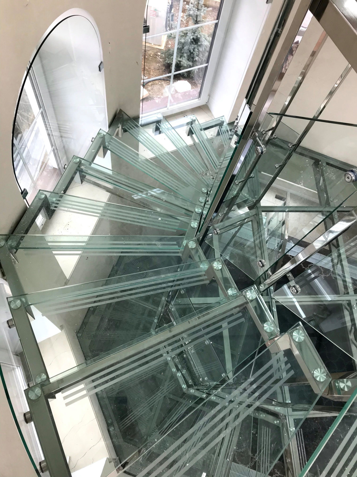 Винтовая стеклянная лестница над бассейном