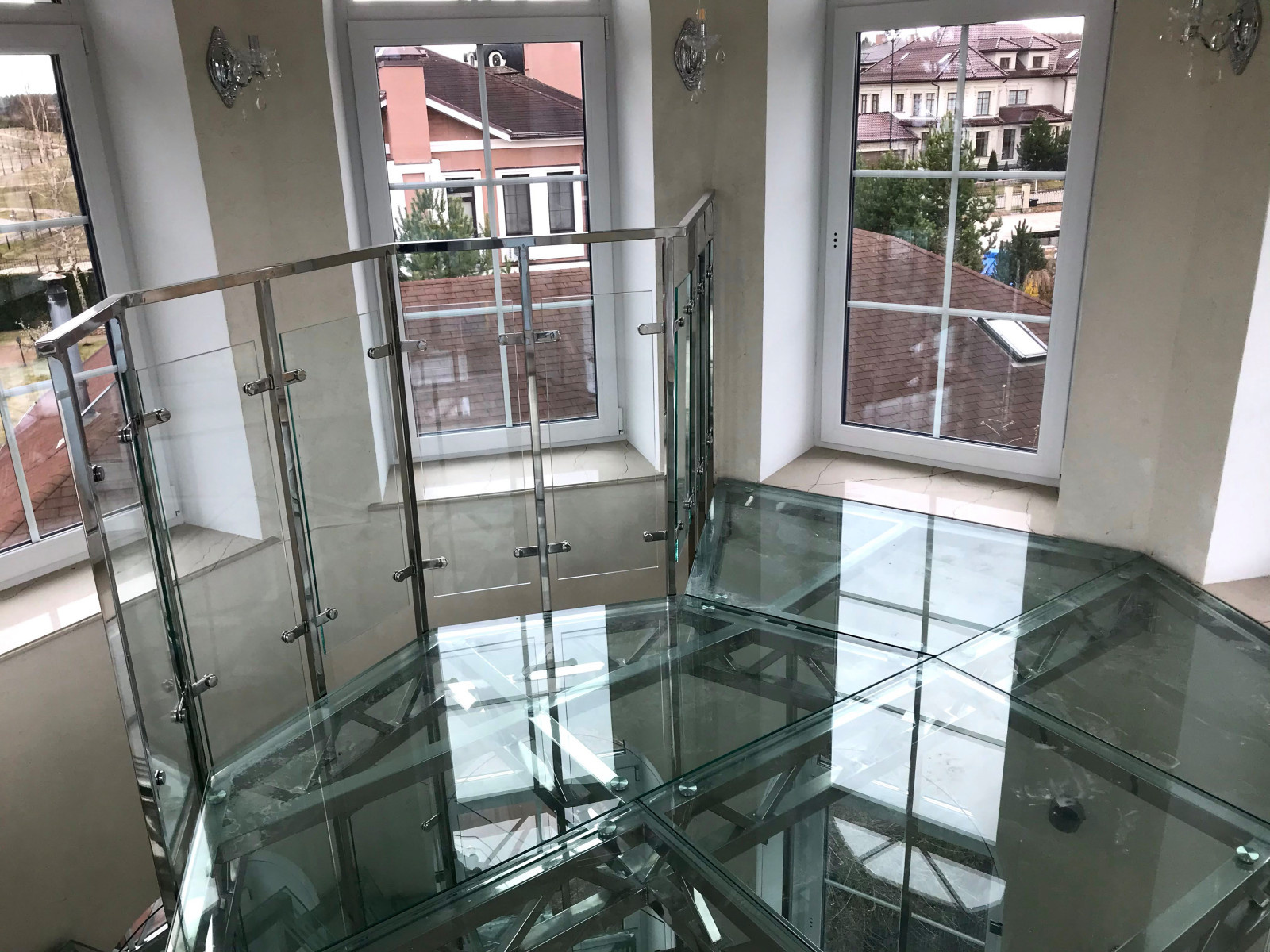 Винтовая стеклянная лестница над бассейном