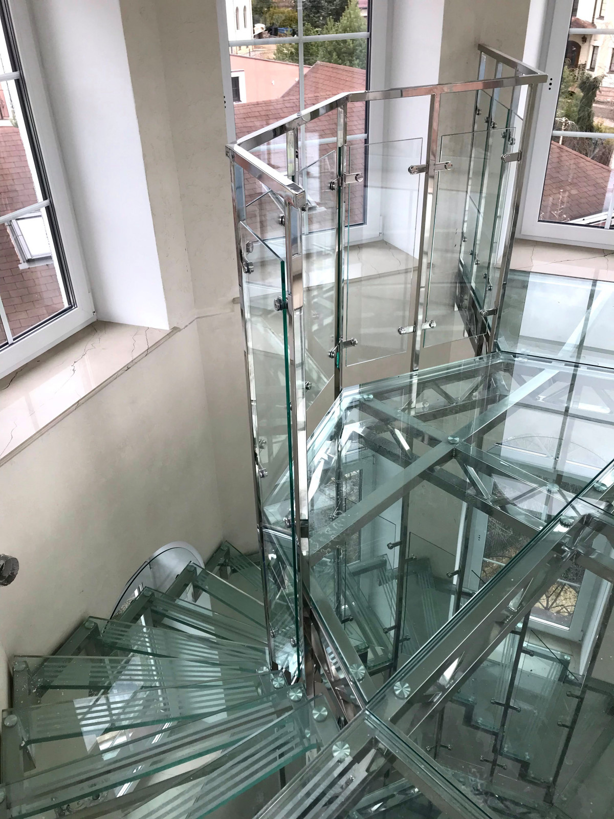 Винтовая стеклянная лестница над бассейном