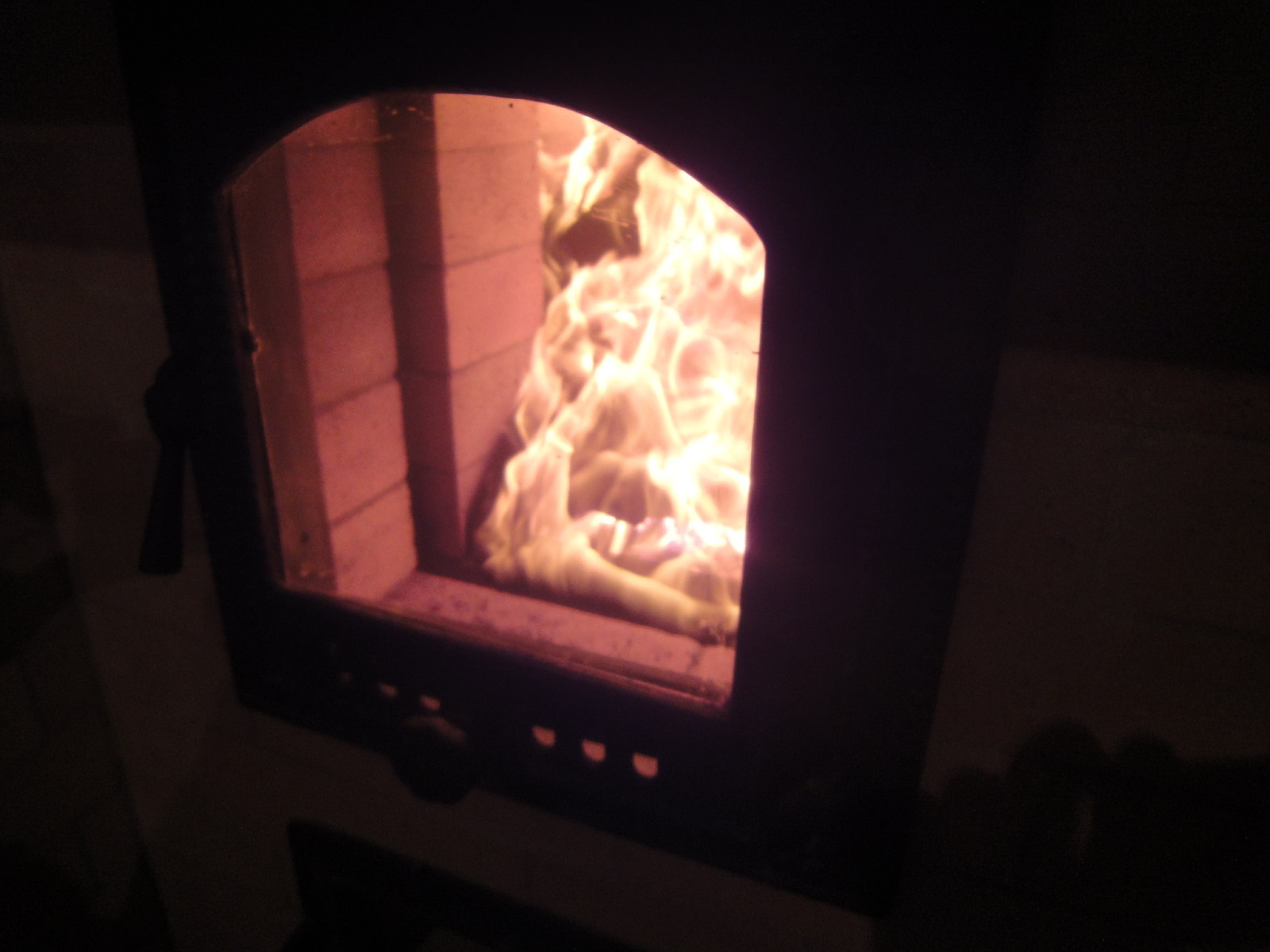 Протопка печи-каменки. Вид из комнаты отдыха через стеклянную дверцу (Финл.)