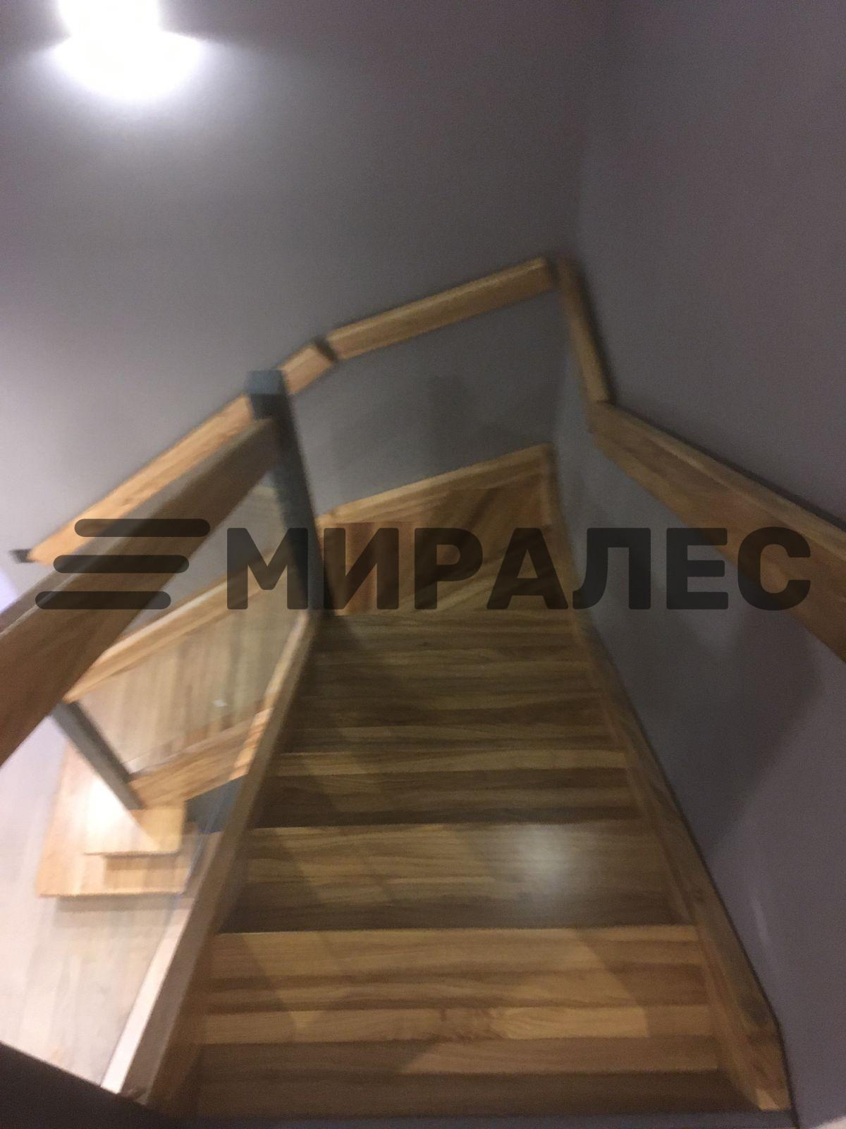 Г-образная лестница из дуба с ограждениями из стекла