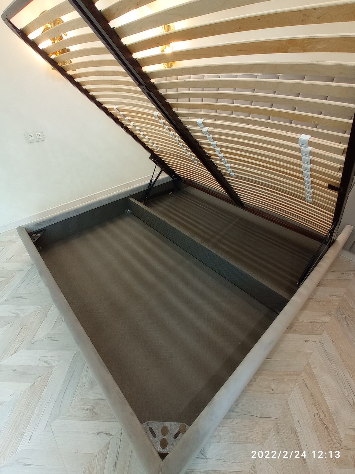 Серая кровать с панелями и золотыми бра