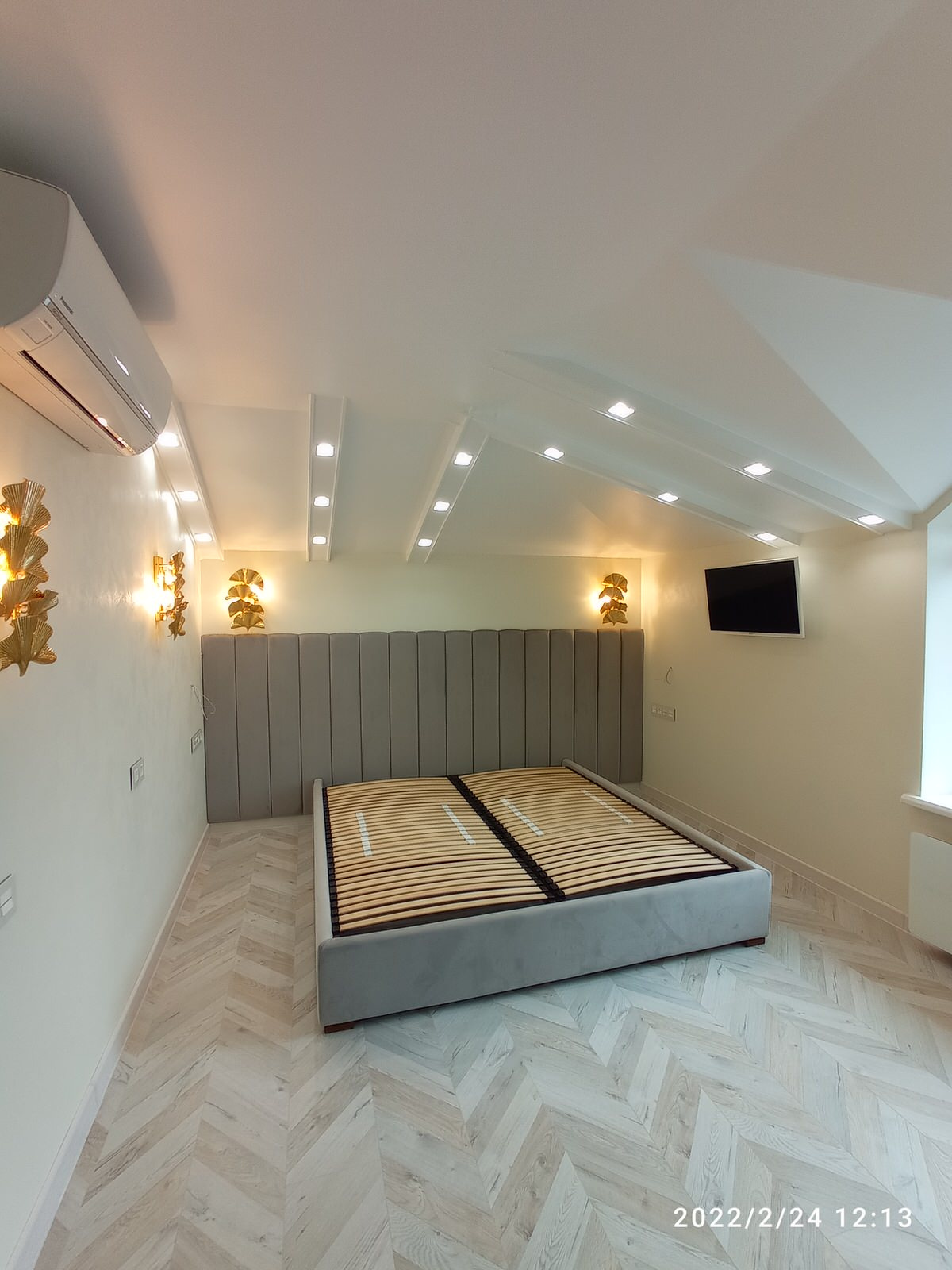 Серая кровать с панелями и золотыми бра