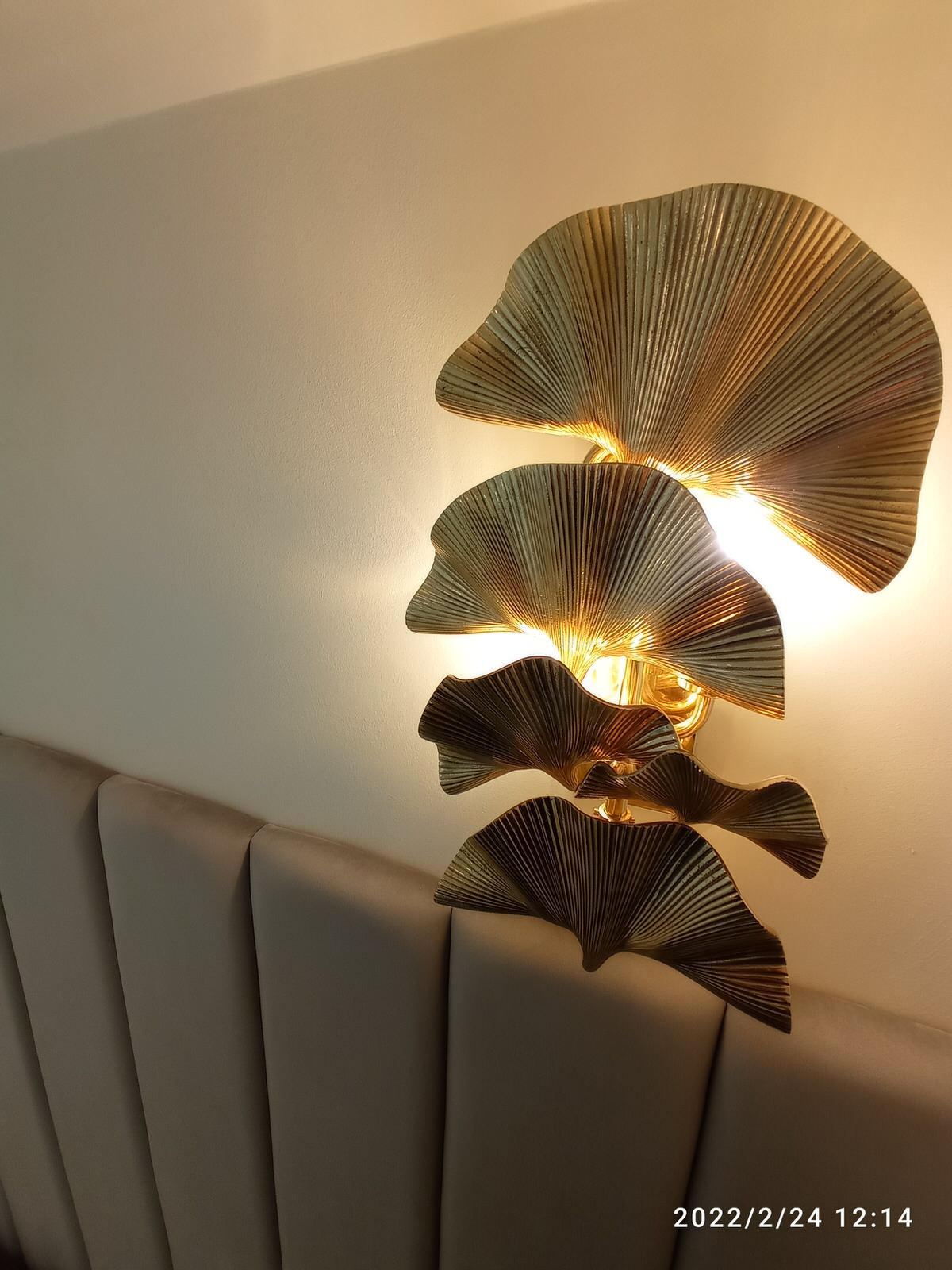 Серая кровать с панелями и золотыми бра