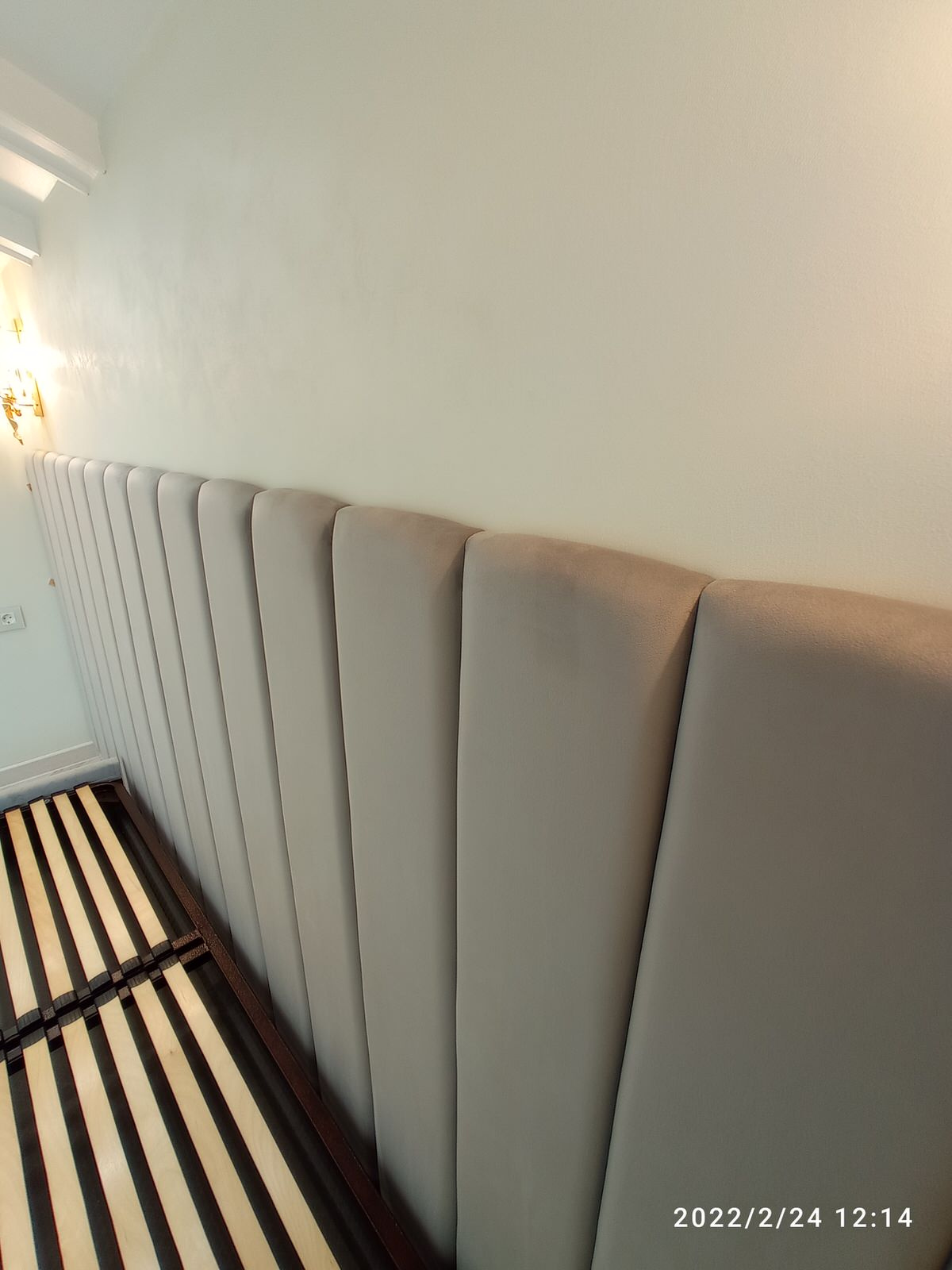 Серая кровать с панелями и золотыми бра