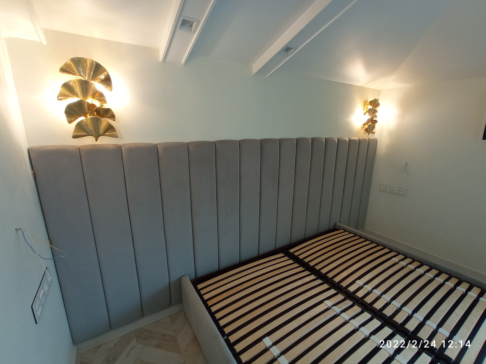 Серая кровать с панелями и золотыми бра