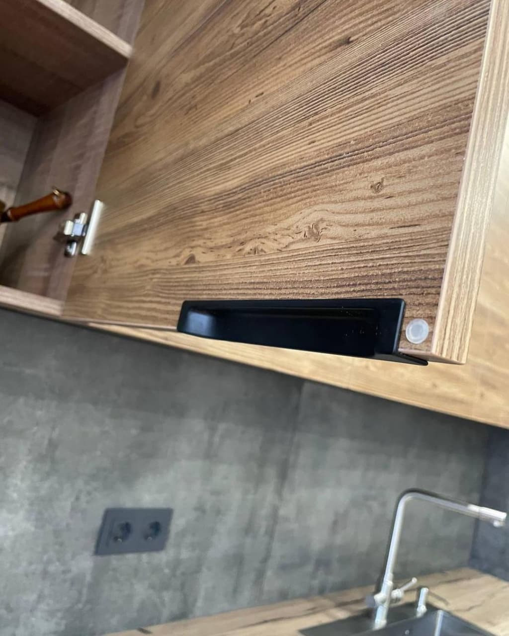 Большая угловая встроенная кухня в черном и коричневом цвете с витриной