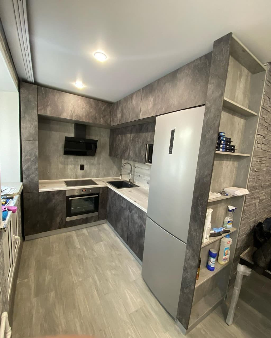 Встроенная черная угловая кухня в стиле лофт с бутылочницей