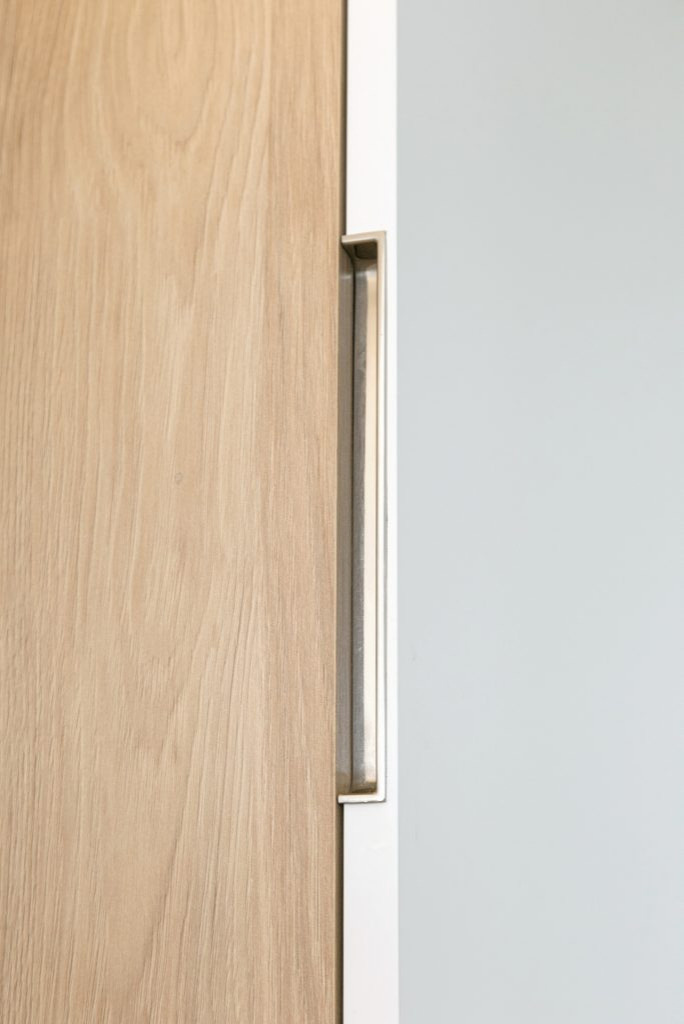 Белая глянцевая кухня с деревянными светлыми фасадами