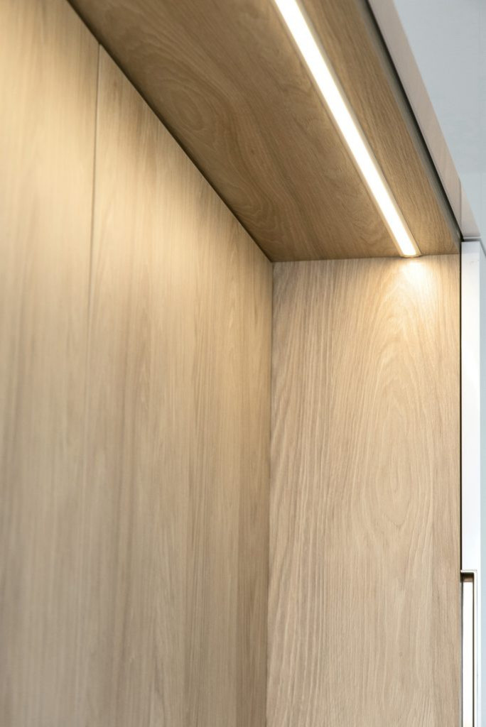 Белая глянцевая кухня с деревянными светлыми фасадами