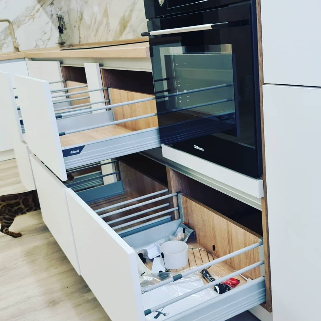 Уютная угловая кухня с фасадами под дерево и серыми матовыми фасадами