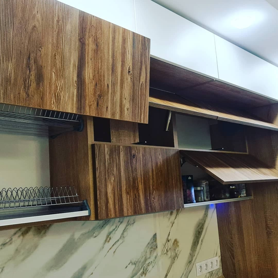 Уютная угловая кухня с фасадами под дерево и серыми матовыми фасадами