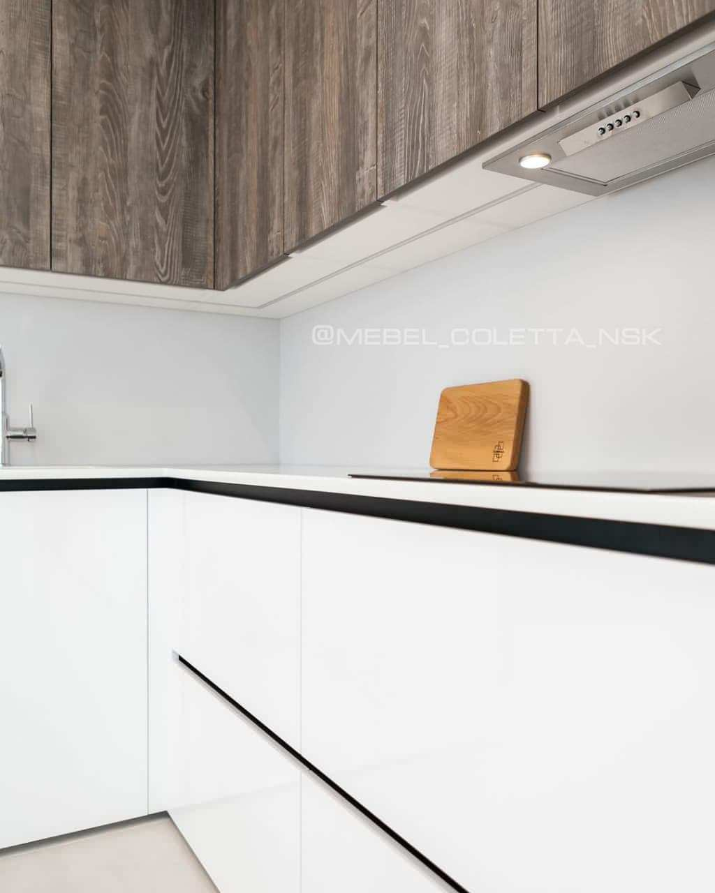 Современная серо-белая кухня в высокими шкафами и барной стойкой