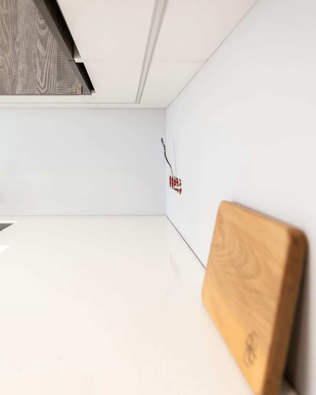 Современная серо-белая кухня в высокими шкафами и барной стойкой