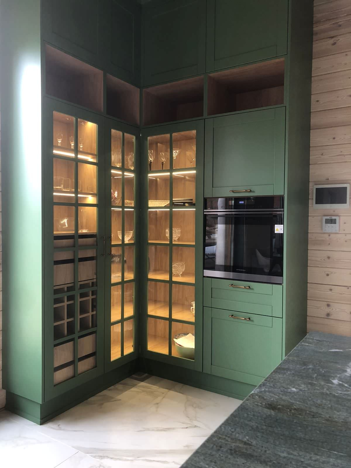 Кухня в зеленом и древесном тонах с подсветкой и оригинальным островом