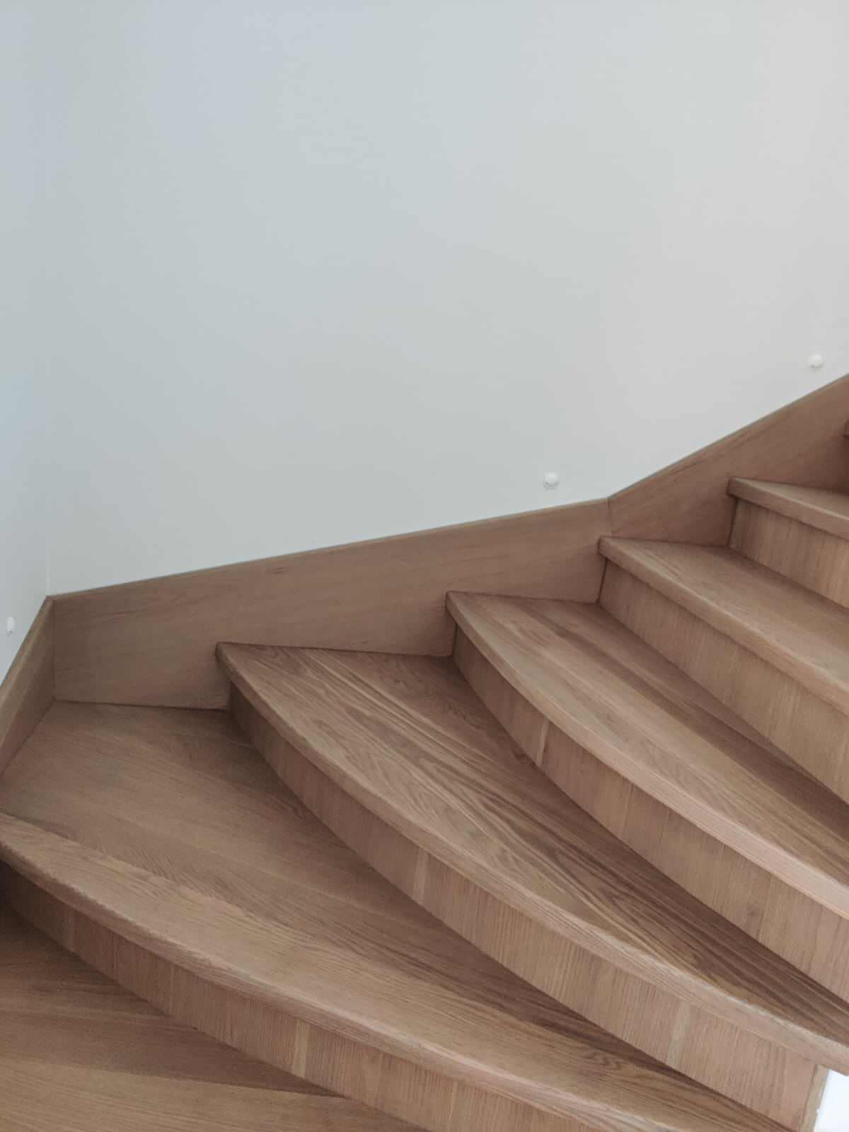 Лестница с забежными ступенями, материал - дуб, покрытие - лак.