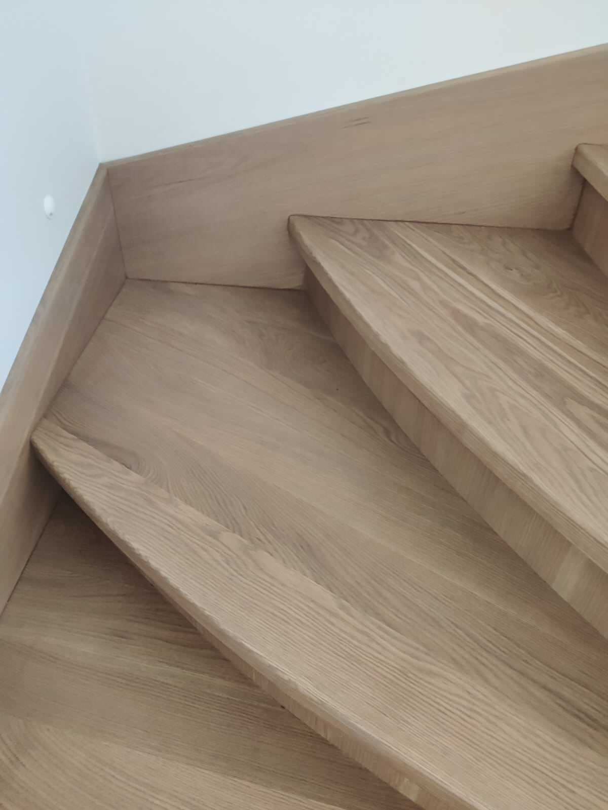 Лестница с забежными ступенями, материал - дуб, покрытие - лак.