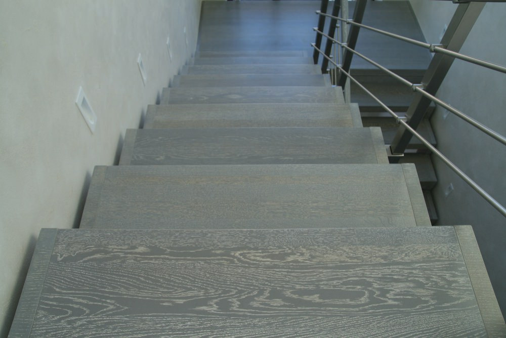 Modern metal stair covered by patina oak