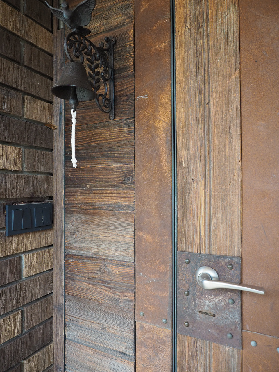 Входная дверь декорирована старым деревом и листовым аутентичным металлом.