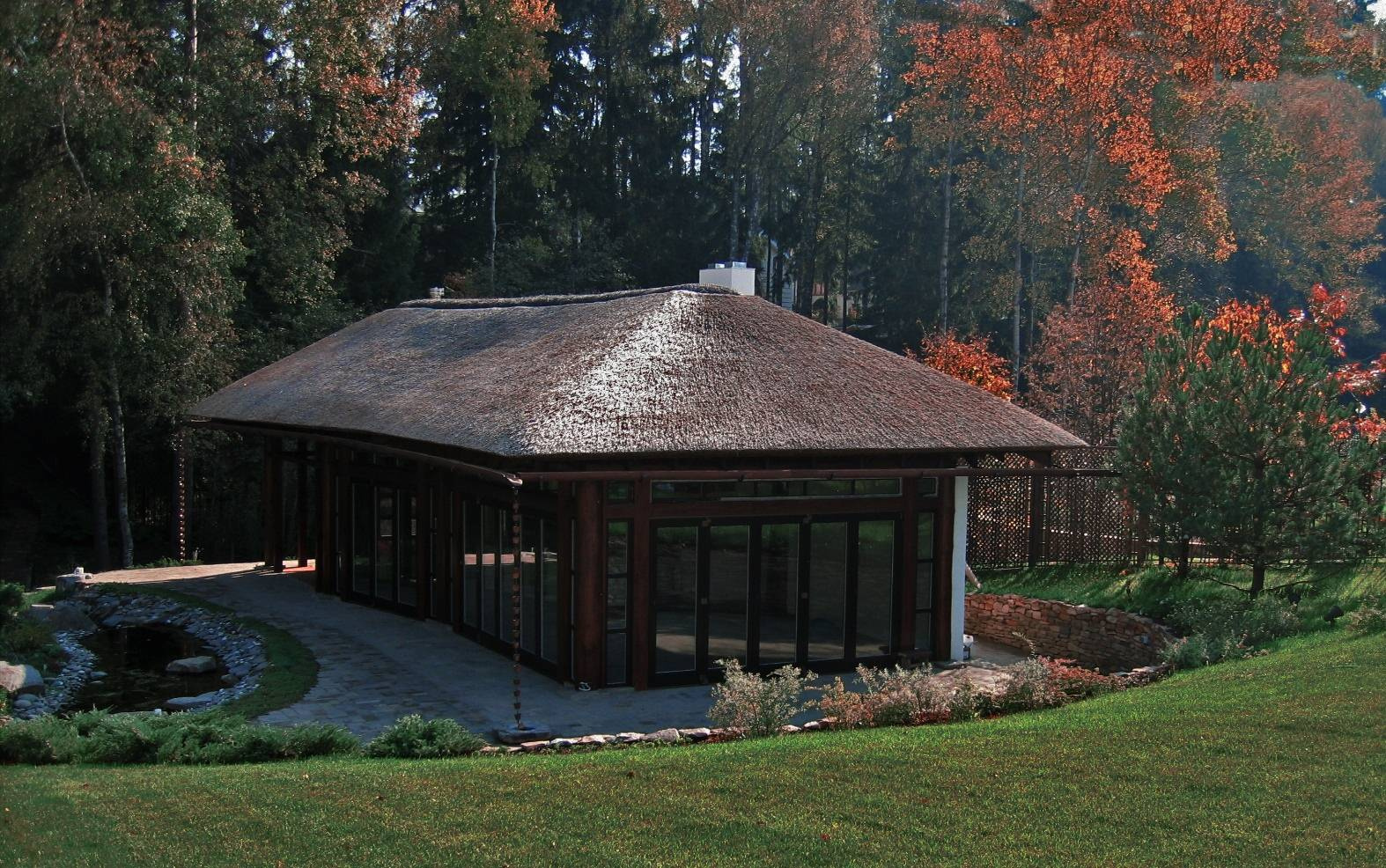 Павильон с соломенной крышей и сад у реки