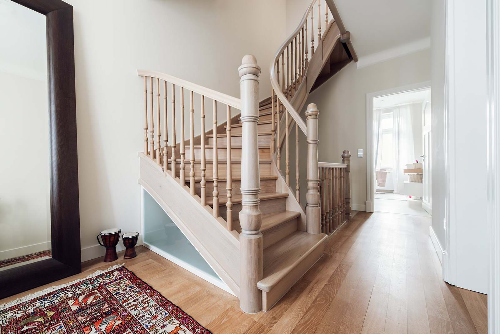 Классическая лестница из дуба с изогнутыми перилами