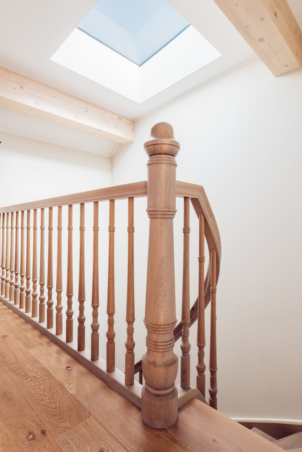 Классическая лестница из дуба с изогнутыми перилами