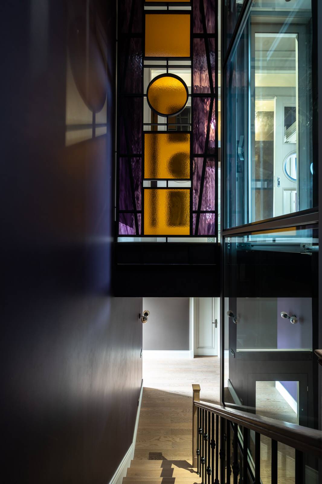 Дом для семьи в Куркино. Лестничное пространство с витражной перегородкой и лифт