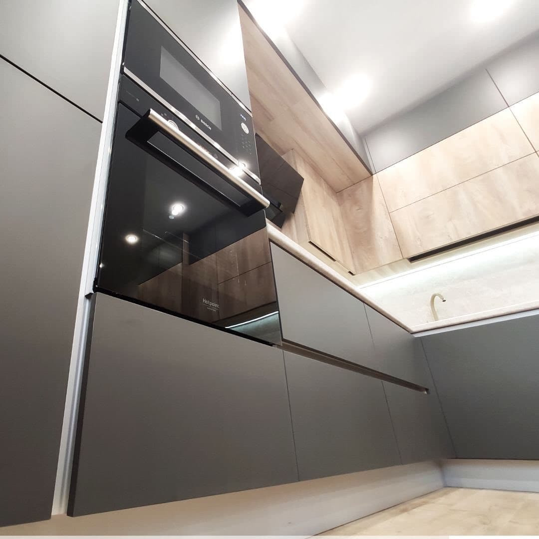 Большая широкая угловая кухня с матовыми и древесными фасадами