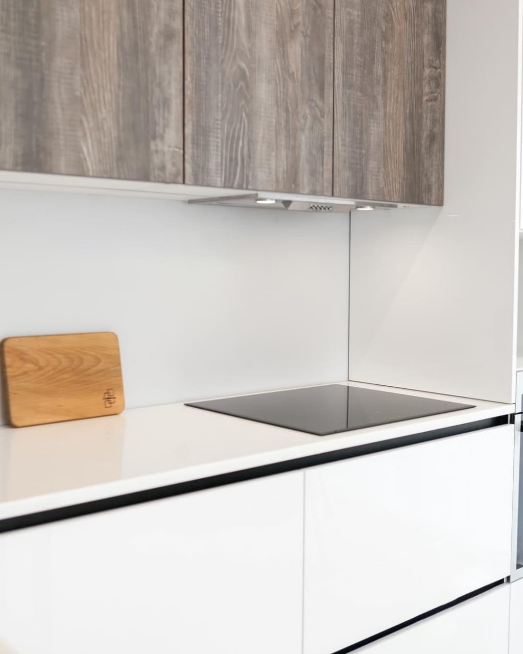 Современная серо-белая кухня в высокими шкафами и барной стойкой