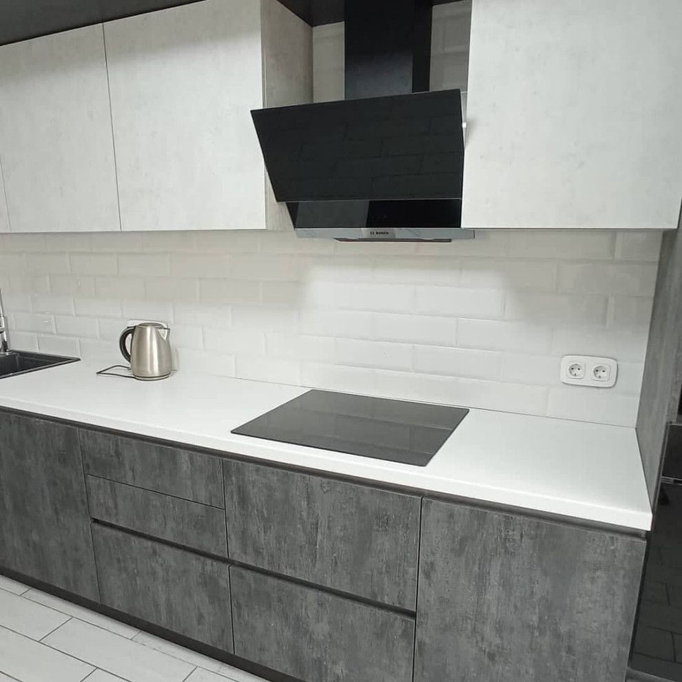 Широкая угловая черно-белая кухня с фасадами под камень