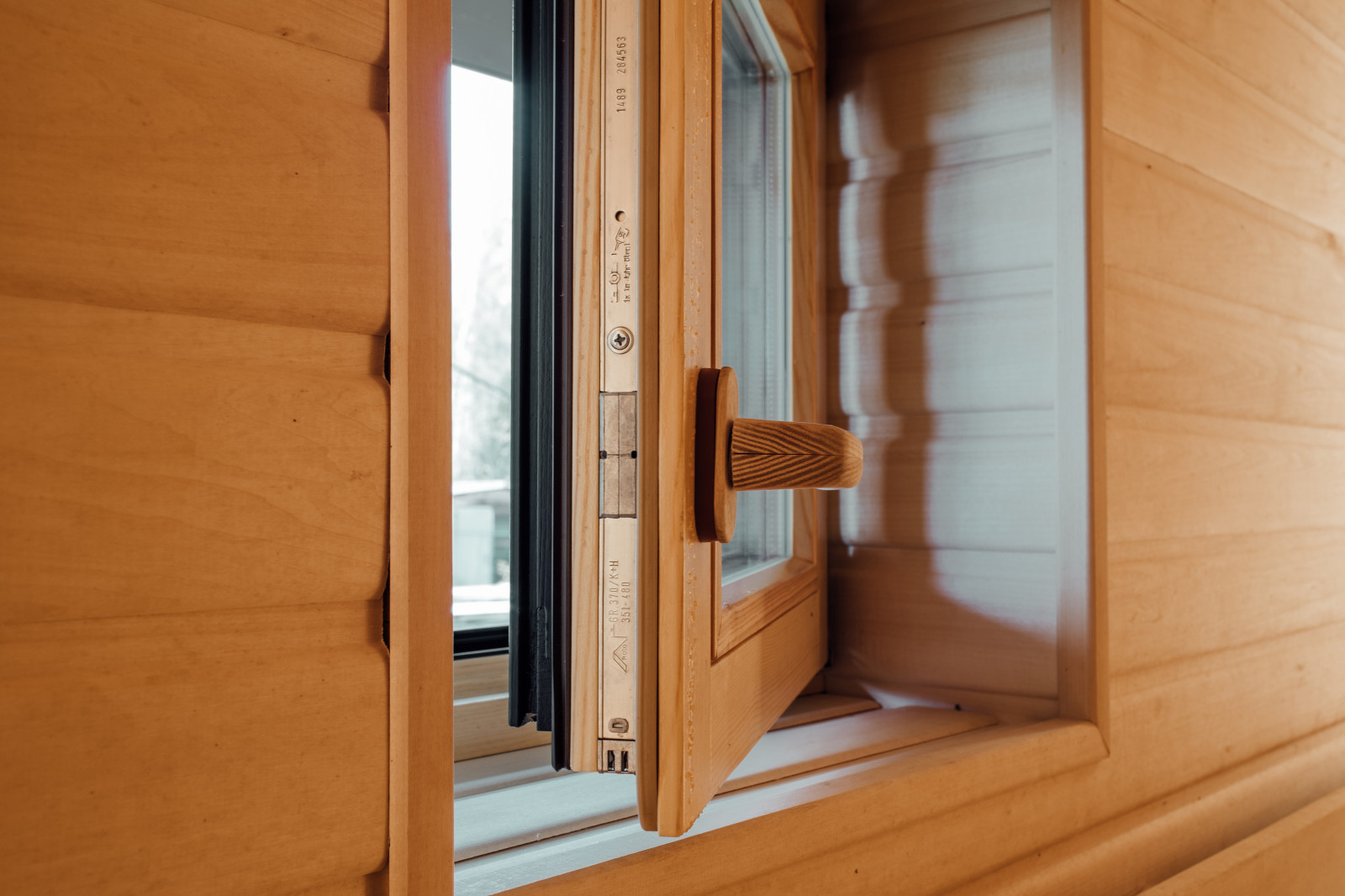 Деревянное окно в баню с деревянной ручкой.
