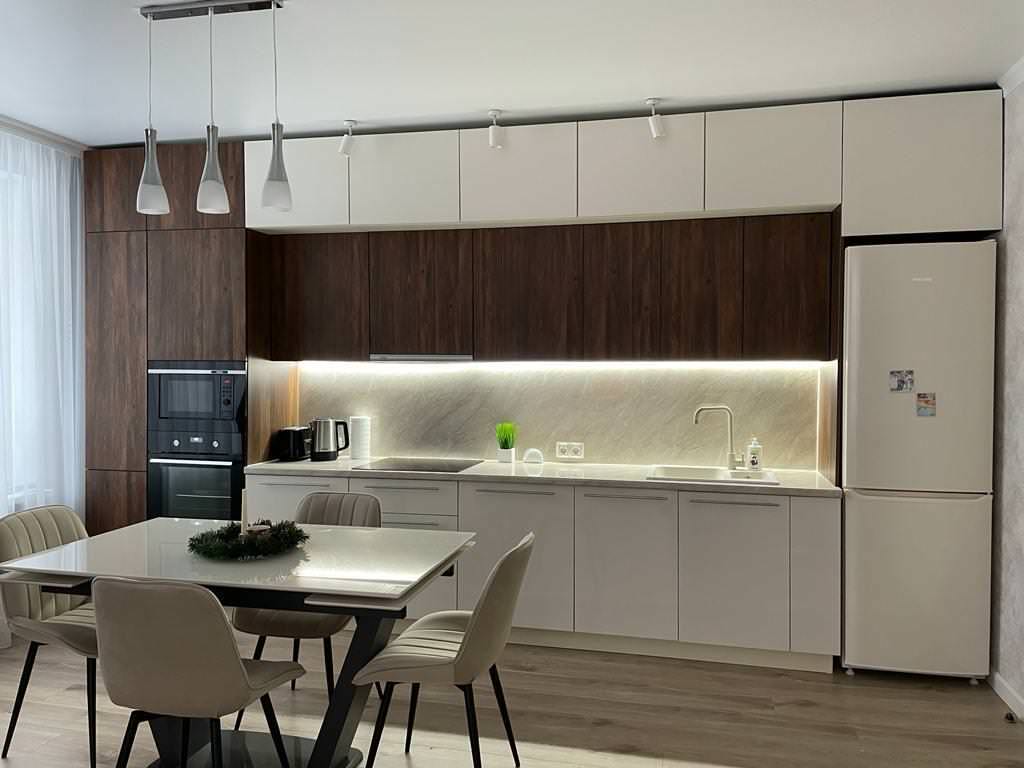 Прямая стильная кухня под потолок с глянцевыми и древесными фасадами