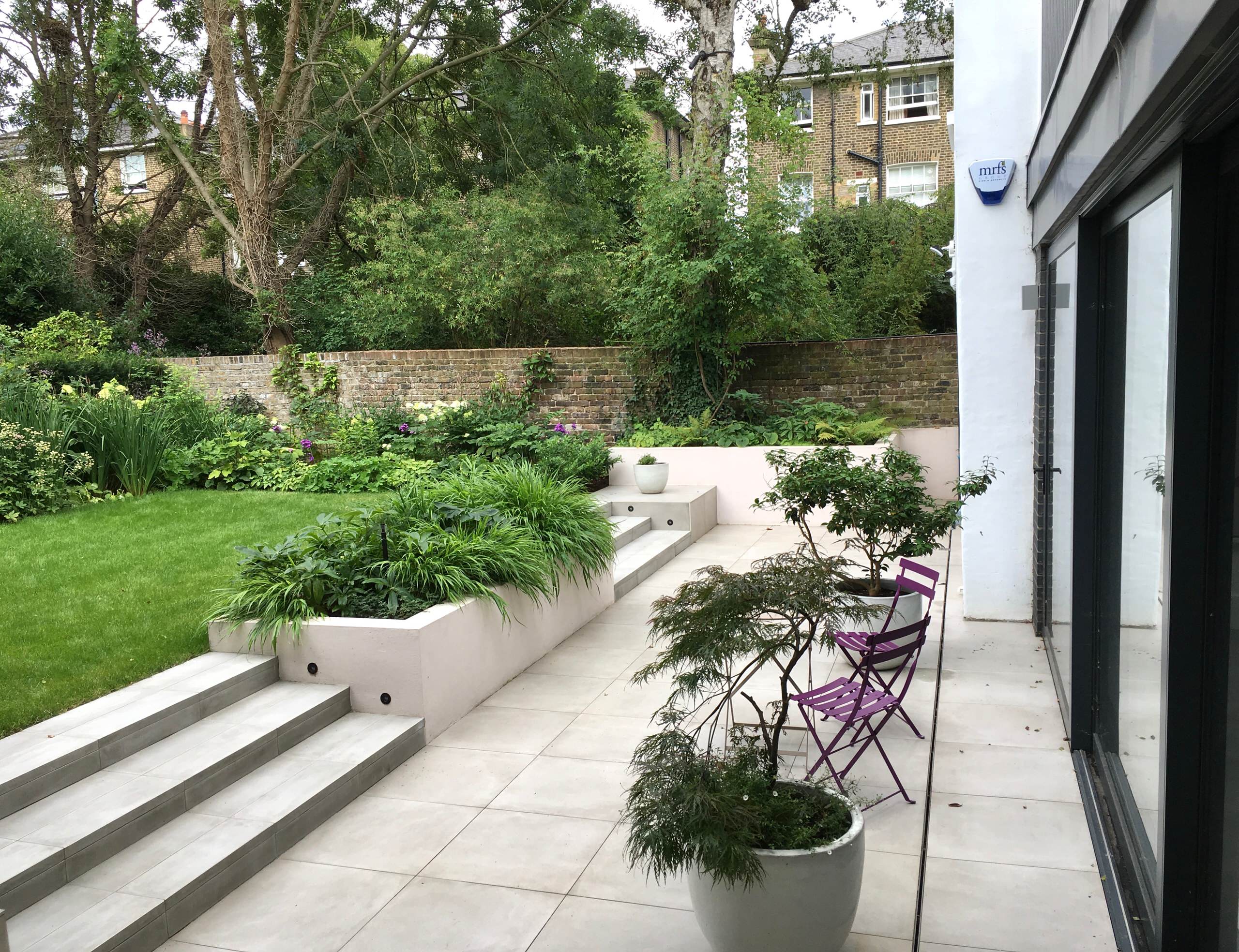 До и после: Пышный сад с эффектной каменной стеной