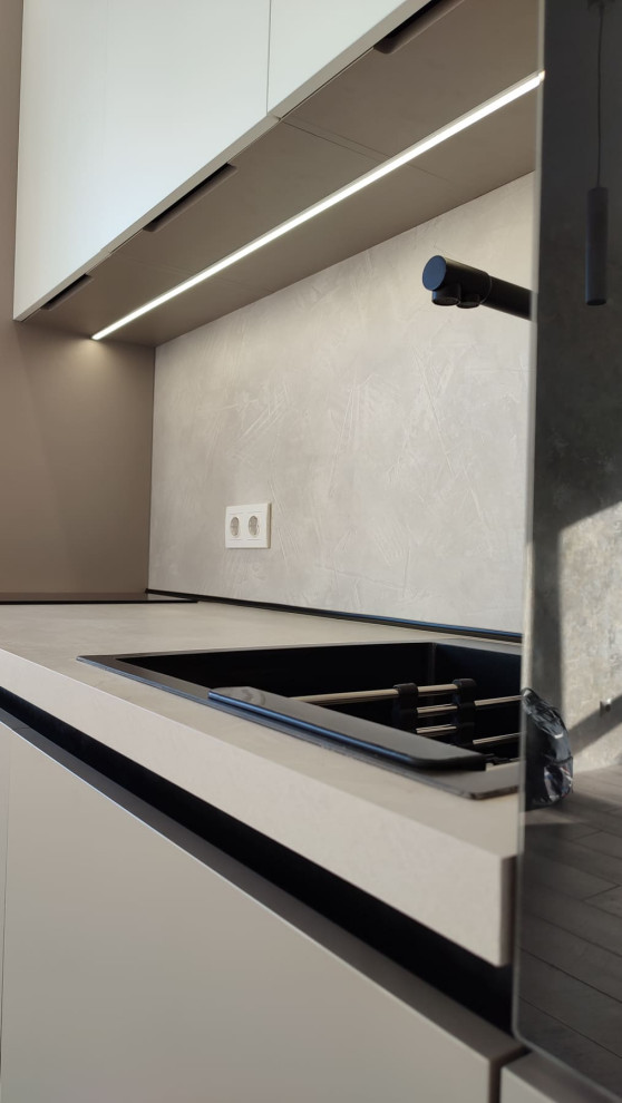 Небольшая встроенная кухня в серо-белом цвете с однотонными фасадами