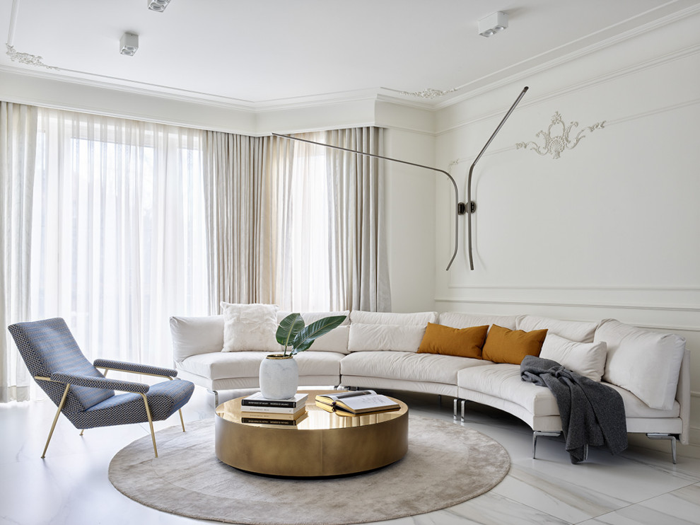 Просторная кухня-гостиная в светлых тонах. Радиусный диван и круглые формы ковра