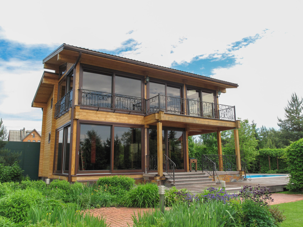 Панорамное остекление загородного дома окнами и порталами из сосны