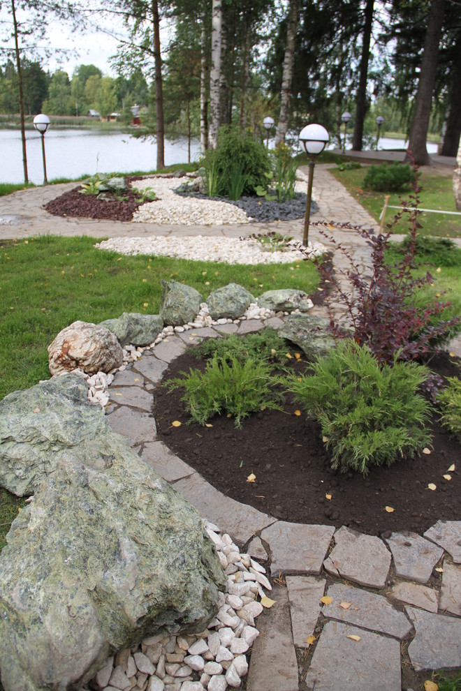 Цветник с камнями и композицией из кустарника