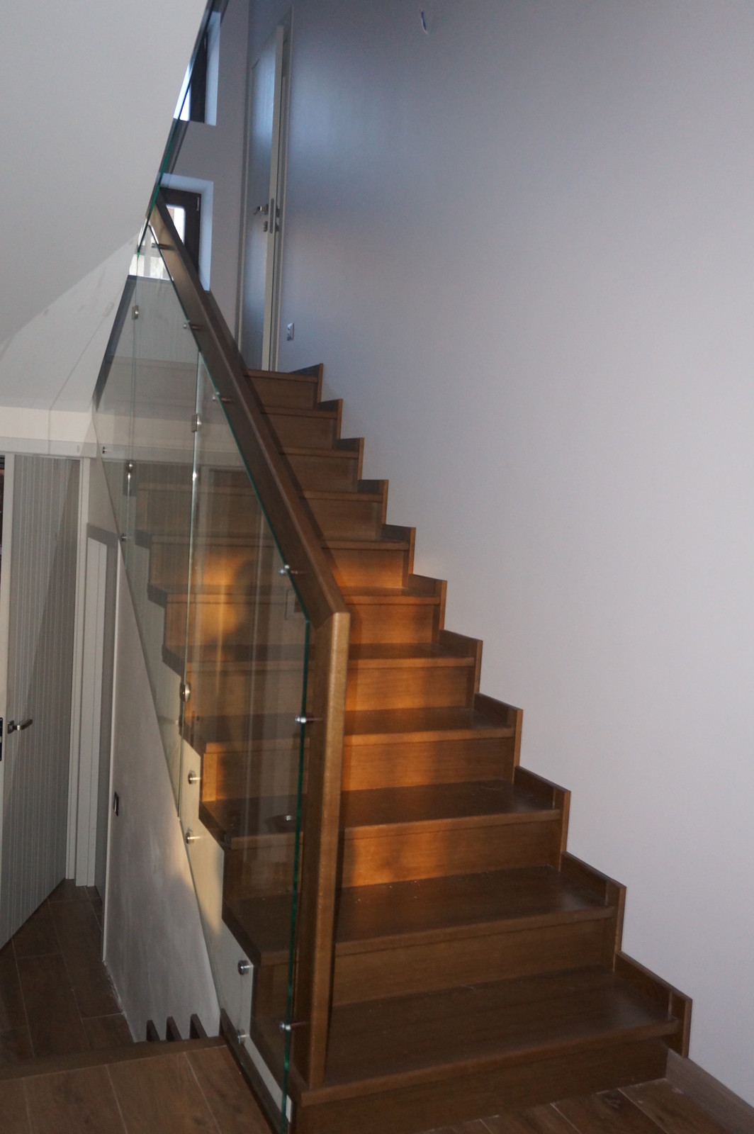 Облицовка бетонной лестницы со стеклянным ограждением в таунхаусе 3 этажа