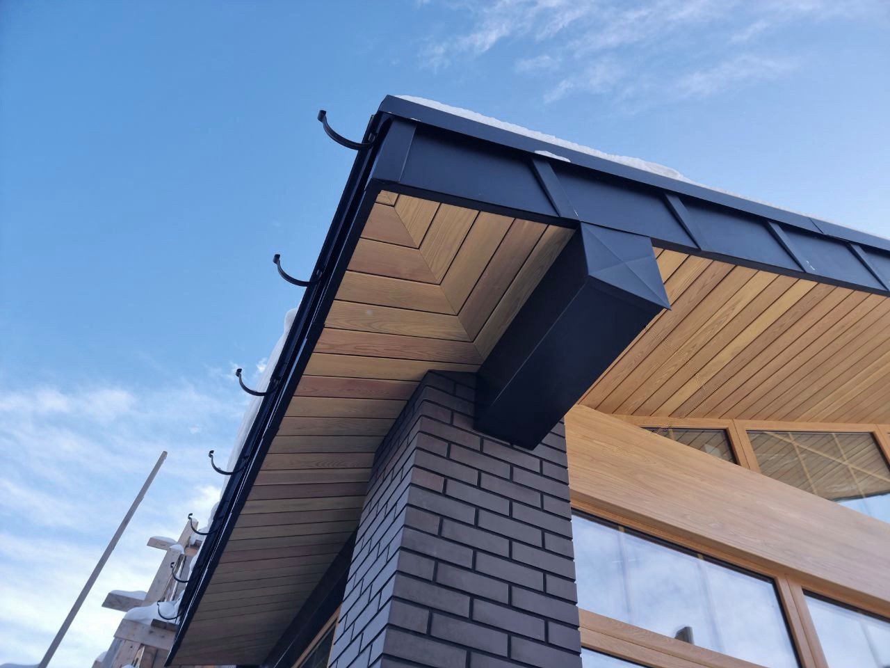 Подшивка свесов. Комбинация из планкена (лиственница) и фальца (сталь SSAB)