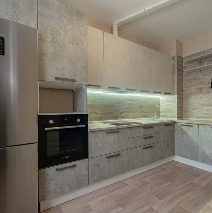 Угловая серо-белая кухня с современными ручками и фасадами под камень