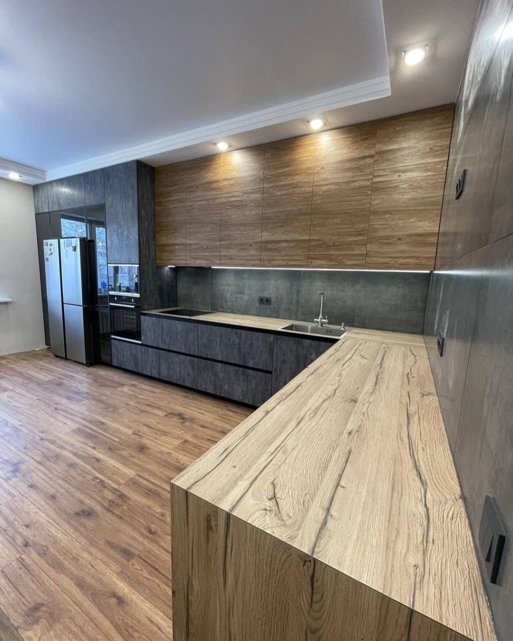 Большая угловая встроенная кухня в черном и коричневом цвете с витриной