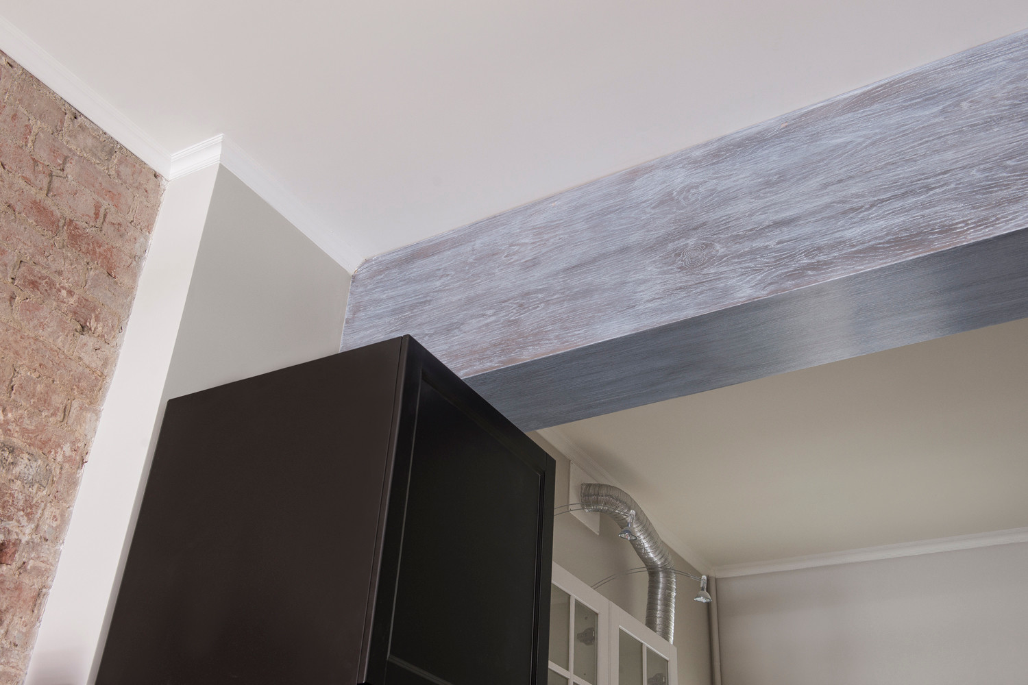 Кухня, декоративные балки и мебель в квартире с современным дизайном