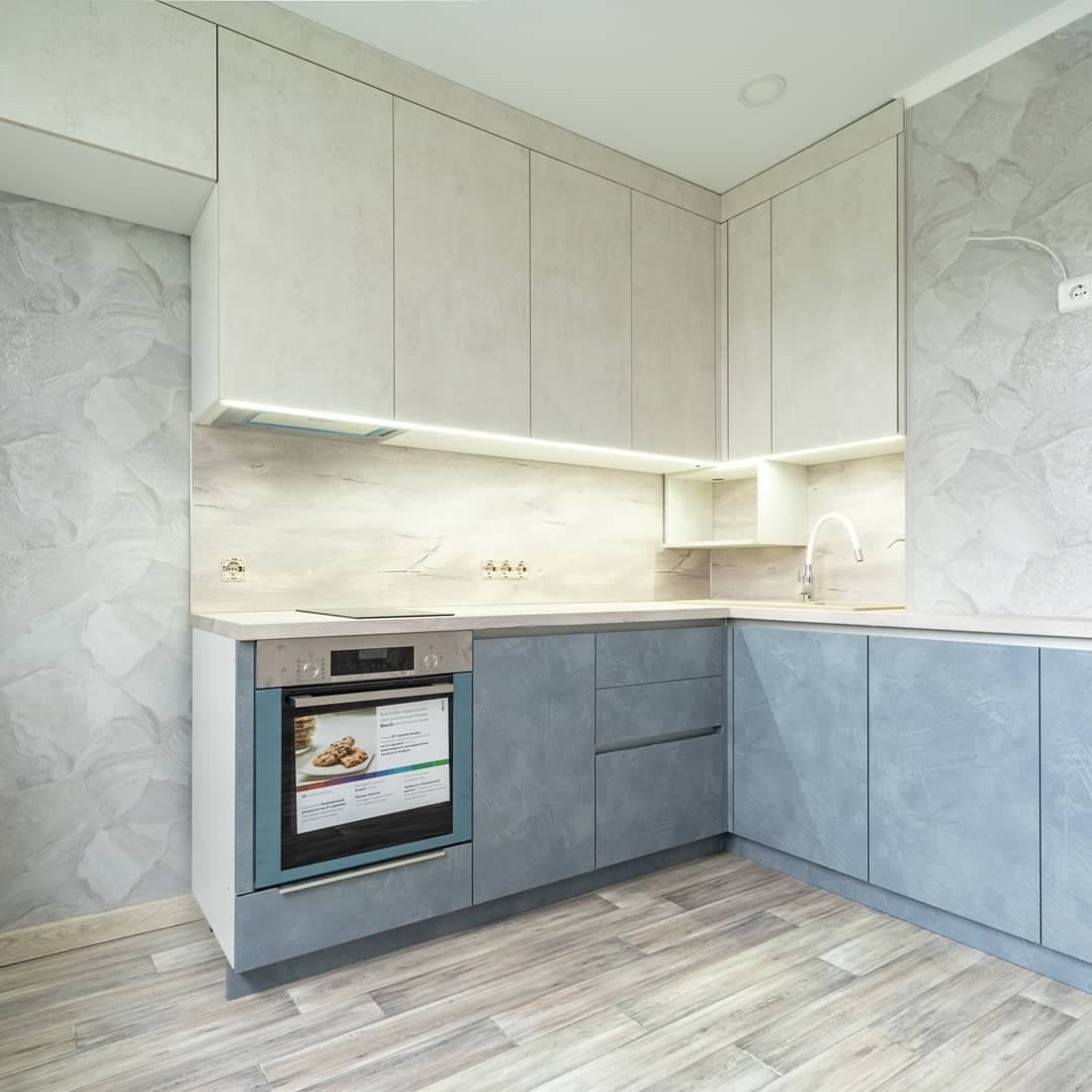 Большая угловая кухня в синем и белом цвете с фасадами под камень