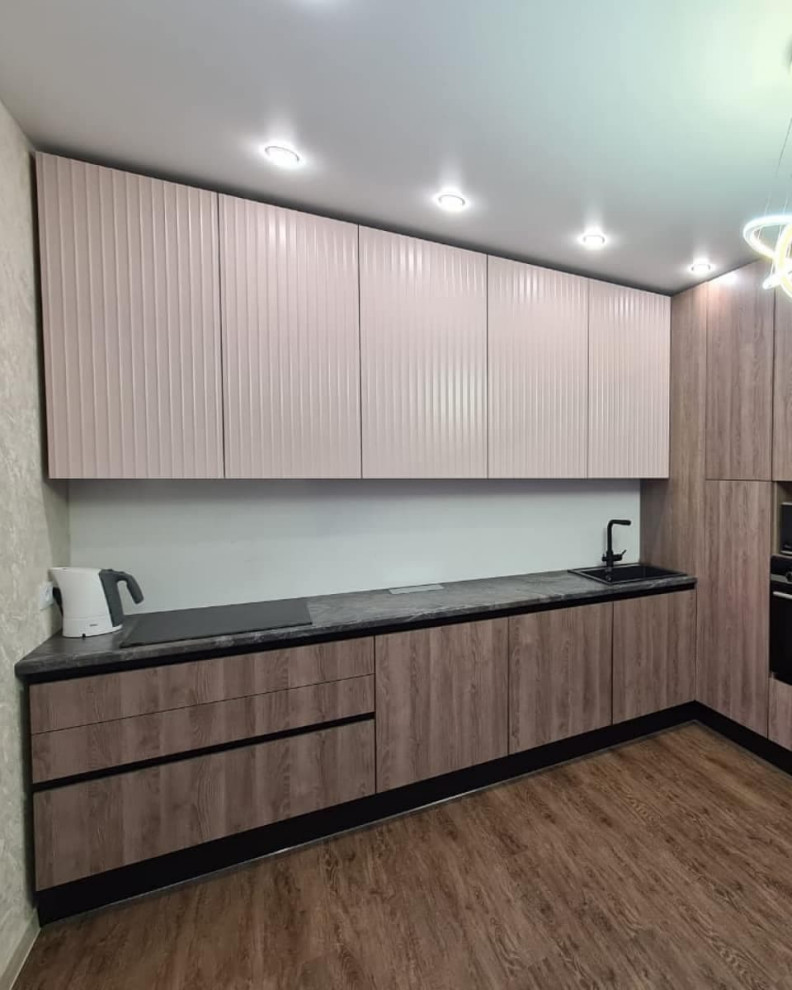 Большая угловая кухня в сером цвете с рифлеными фасадами и витриной