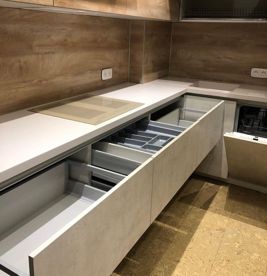 Встроенная угловая кухня с каменными и древесными фасадами