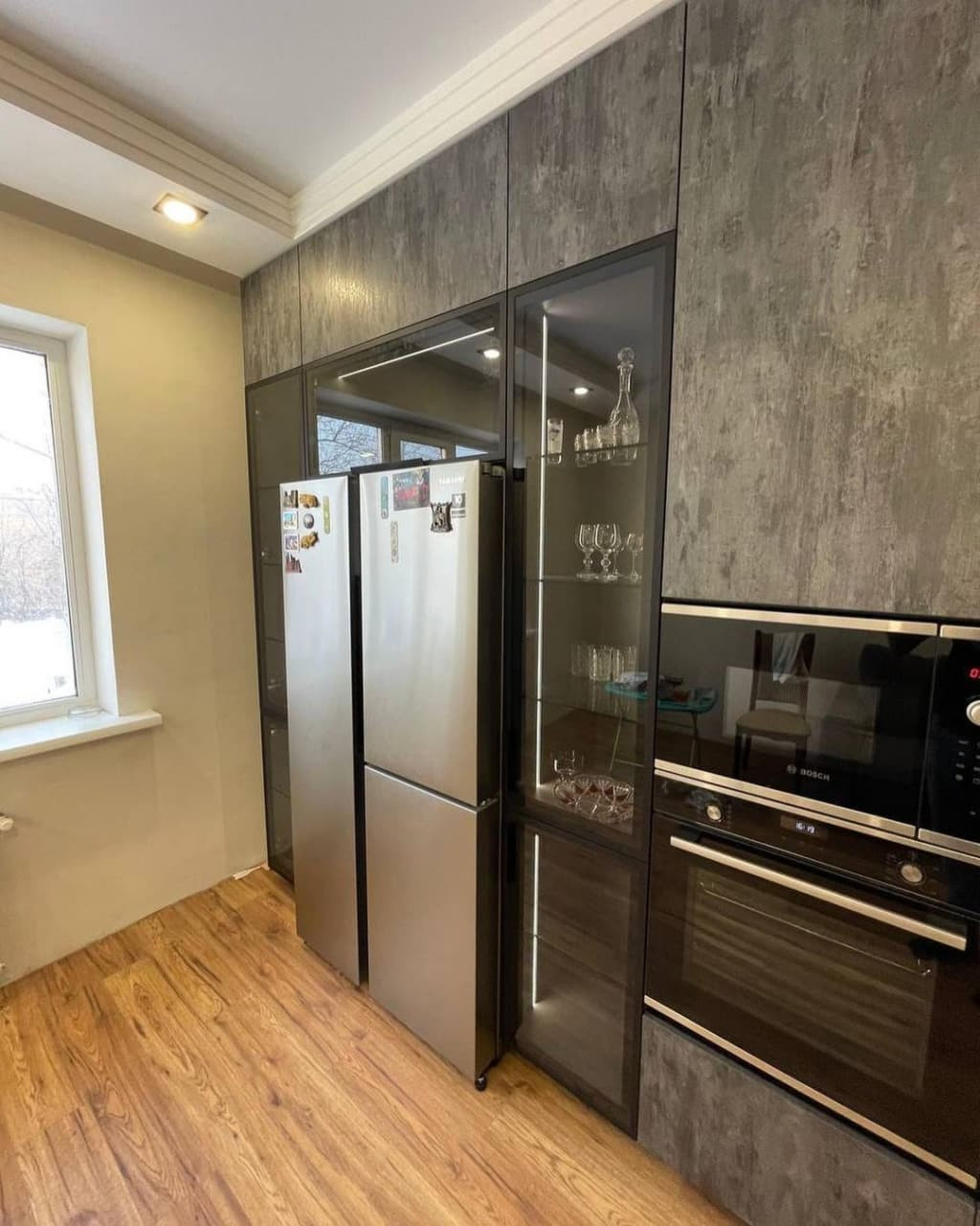 Большая угловая встроенная кухня в черном и коричневом цвете с витриной