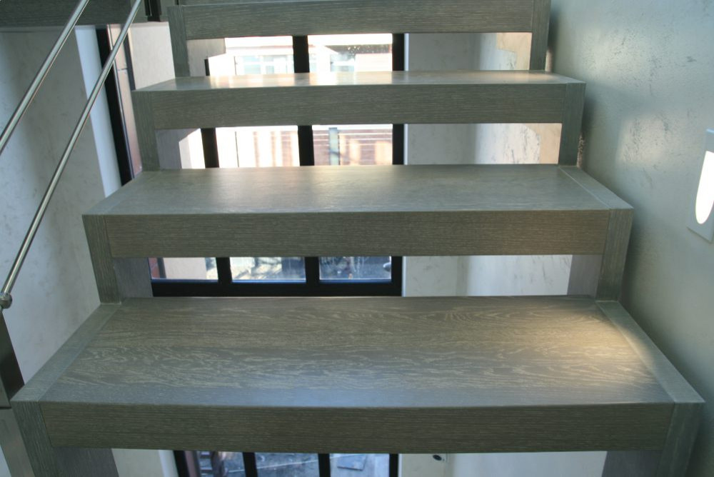 Modern metal stair covered by patina oak