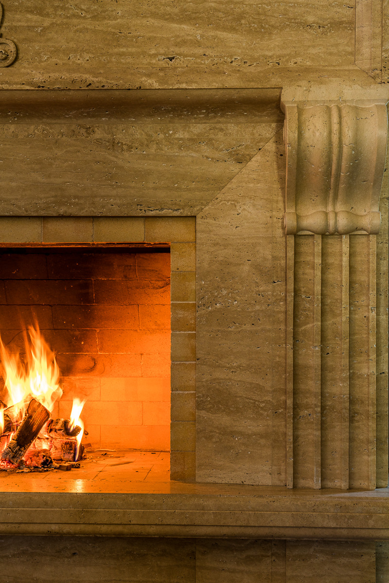 Камин из травертина в загородном доме.