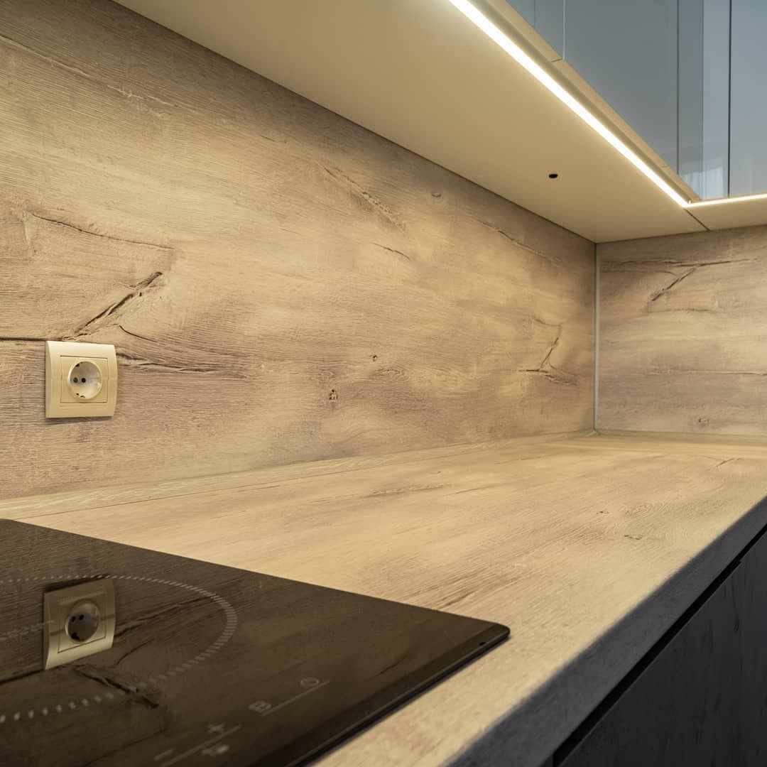 Угловая встроенная кухня с белыми глянцевыми и каменными фасадами