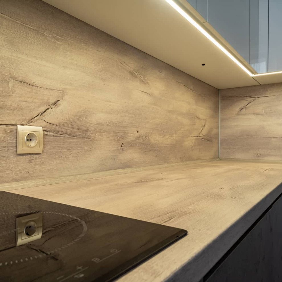 Угловая встроенная кухня с белыми глянцевыми и каменными фасадами